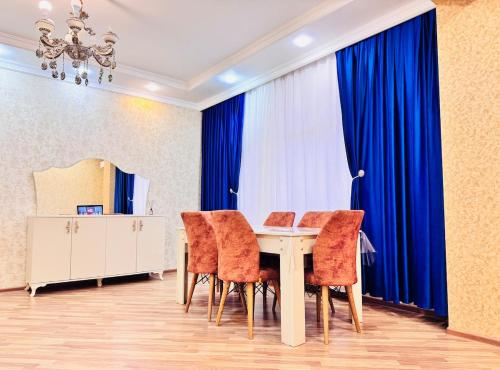 una sala da pranzo con un tavolo con sedie arancioni di Panoramic Apartment a Baku