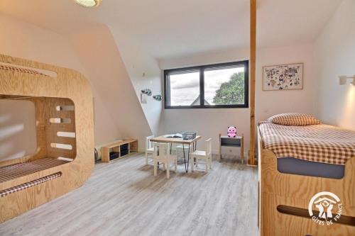 a bedroom with a bunk bed and a table at Les maisons de l'if - le cottage in Pluméliau