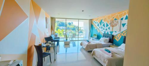 a hotel room with two beds and a table and a desk at Veloche Karon 12 in Karon Beach
