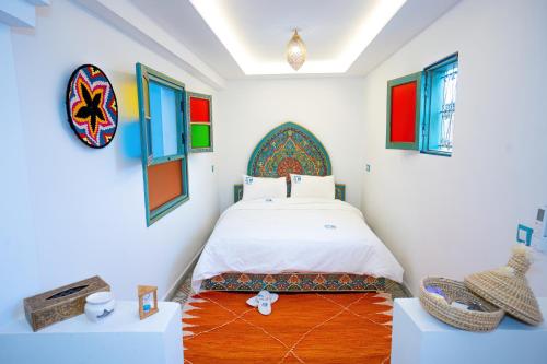a bedroom with a bed and some pictures on the wall at Dar Fayrouz in Fez