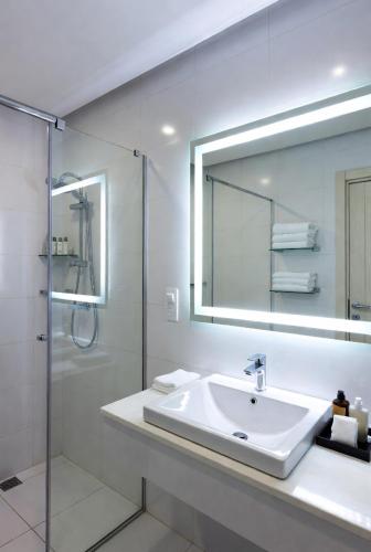 a white bathroom with a sink and a shower at Golden view hotel Tanzania in Dar es Salaam