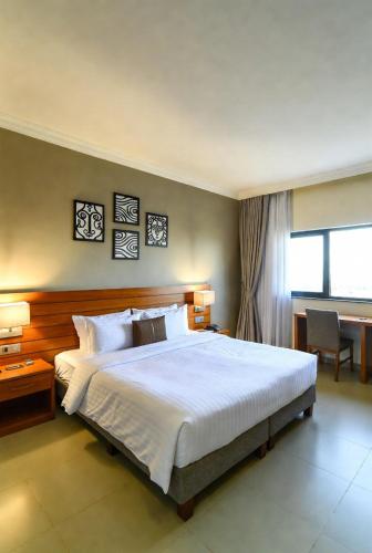 a bedroom with a large bed and a desk at Golden view hotel Tanzania in Dar es Salaam