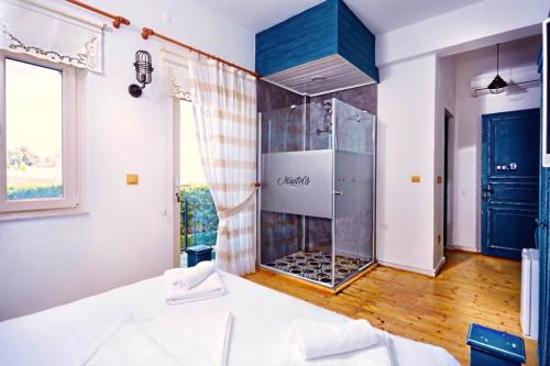 a bathroom with a glass shower in a room at Müptela Alaçatı in Çeşme