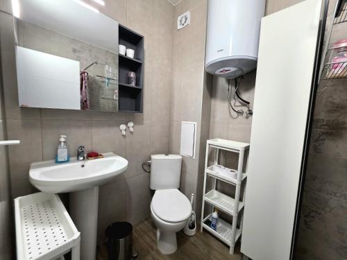 a small bathroom with a toilet and a sink at Sunny studio in Shartrez in Shkorpilovtsi