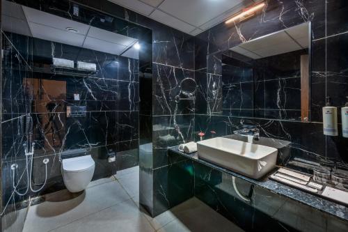 a bathroom with a sink and a toilet at Lords Studio Inn, Jamnagar in Jamnagar