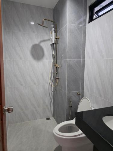 a bathroom with a shower and a toilet and a sink at Luangwang Resort in Nai Yang Beach