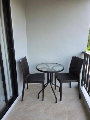a table and two chairs and a glass table and chairs at Luangwang Resort in Nai Yang Beach