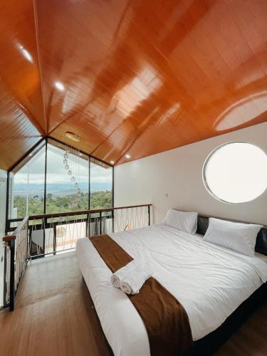 a bedroom with a large bed with a large window at Villa with jacuzzi, Damar Ningrum 5 in Panjadakan