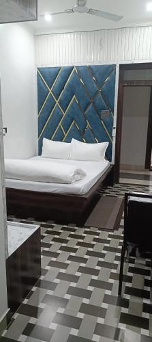 a large bed in a room with a checkered floor at Hotel Laxmi villa in Naini