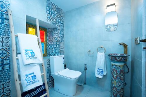 a blue bathroom with a toilet and a towel at Dar Fayrouz in Fez