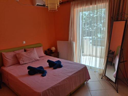 a bedroom with a bed with two blue shoes on it at Big Terrace 180 view to sea in Akritokhórion