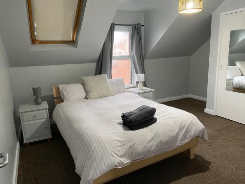 a bedroom with a bed with a black bag on it at Baron Apartment B in Ballymena