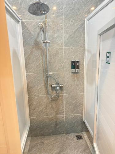 a bathroom with a shower with a glass door at The Sun Backpacker Hostel in Ninh Binh
