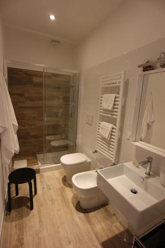 a bathroom with a toilet and a sink and a shower at AL 32 B&B in Massa Marittima