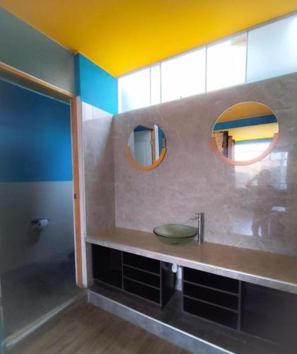 a bathroom with a sink and two mirrors at Shambala Hostel in Huacachina