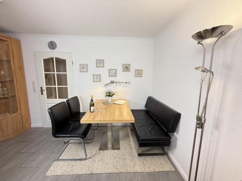 a dining room with a table and black chairs at Wiking, App 019 in Westerland