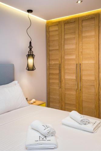 a bedroom with a bed and a chandelier at Meli Boutique Hotel in Limenaria