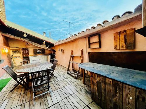 a wooden deck with a table and chairs on a house at Caractère de Beaumes in Beaumes-de-Venise