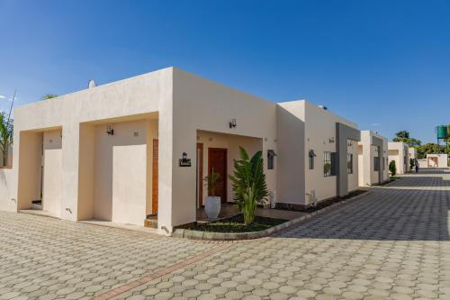 a row of white buildings on a street at Paris Royal Estate in Lusaka