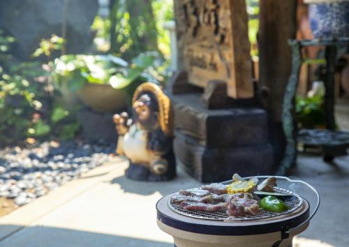 a plate of food on a table with a statue at An old house with a fire pit for rent Guesthouse Yukarian - Vacation STAY 87627v in Egita