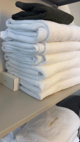 a stack of white towels on a shelf at The Viking s Haven - Heart of Downtown in Reykjavík