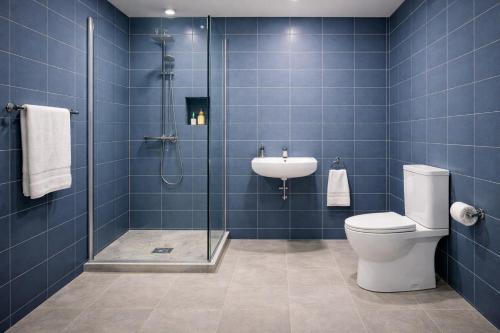 a bathroom with a shower and a toilet and a sink at Colorato Quba in Qırmızı Qǝsǝbǝ