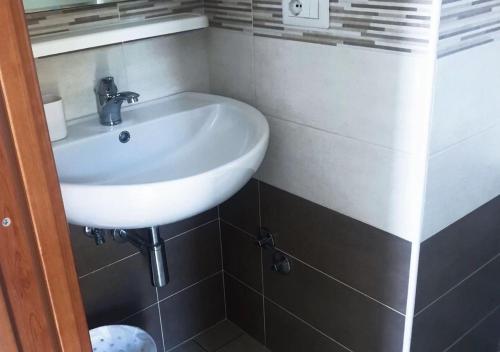 a white sink in a bathroom with black tiles at B&b La Vigna in Furore