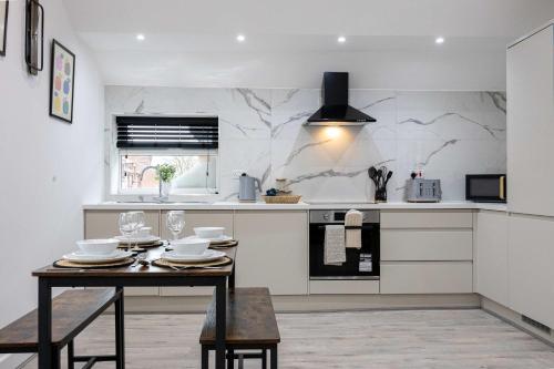 a kitchen with a dining table and a counter at The Knutsford loft in Knutsford