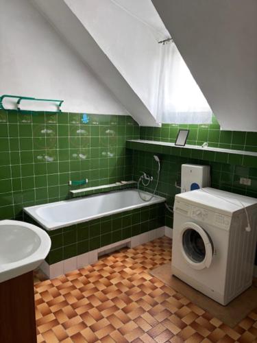 a green bathroom with a washing machine and a sink at House with garden For 8 people in Suwałki