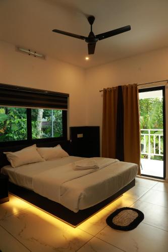 a bedroom with a bed with a ceiling fan at Trinity Homestay Munnar in Anachal