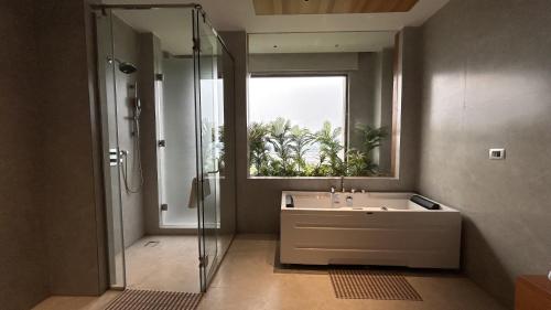 ein Badezimmer mit Waschbecken und Dusche mit Fenster in der Unterkunft Noura Chandigarh - The Green Escape in Panchkula