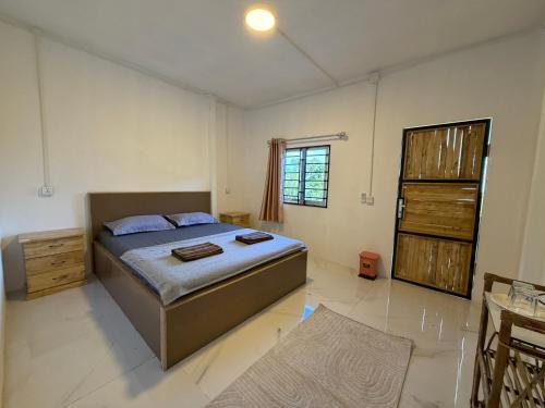 a bedroom with a bed and a table and a window at Hillside Hostel & Bungalows in Kaôh Rŭng (3)