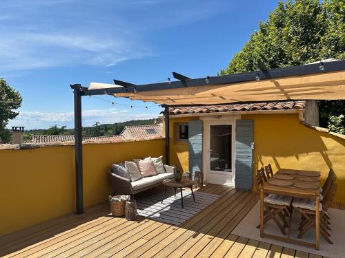 une terrasse avec une table et un canapé sur une terrasse dans l'établissement Charming house, à Villes-sur-Auzon