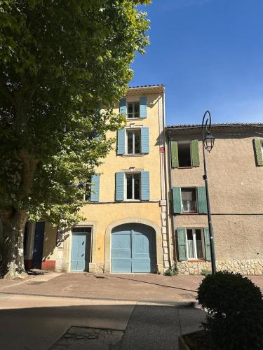 un grand bâtiment en briques avec deux portes de garage dans une rue dans l'établissement Charming house, à Villes-sur-Auzon