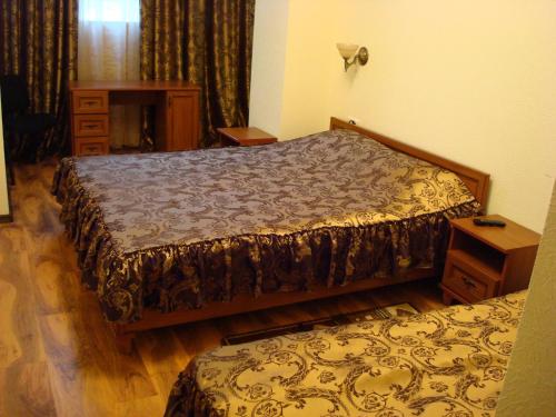 a bedroom with a bed and a dresser and a table at Отель Гармония in Dnipro