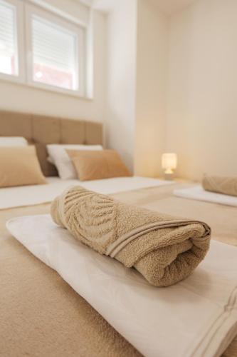 two beds in a bedroom with a blanket on them at Apartmani Otium in Mostar