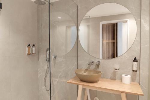 a bathroom with a sink and a shower with a mirror at NOBILIS CORFU Hotel in Acharavi
