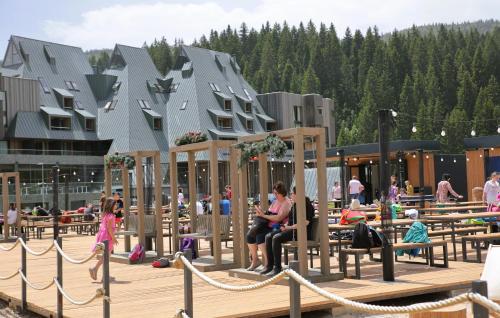 a group of people sitting on a wooden deck at Hotel Monti Spa & Wellness in Igman