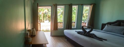 a bedroom with a bed with a large window at The Nap Koh Yao Yai in Ban Nai Wat
