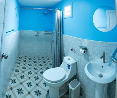 a blue bathroom with a toilet and a sink at The Nap Koh Yao Yai in Ban Nai Wat