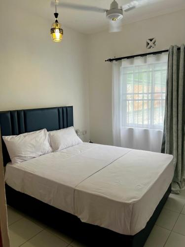 a bedroom with a large bed with a window at Leona Homes in Mombasa