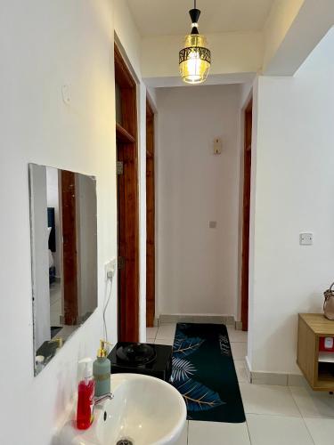 a bathroom with a sink and a mirror at Leona Homes in Mombasa
