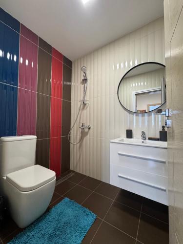 a bathroom with a toilet and a sink and a mirror at Киво апарт Созопол in Sozopol