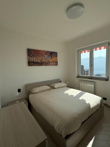 a bedroom with a large bed and two windows at La Dimora del Lago d'Iseo in Sarnico