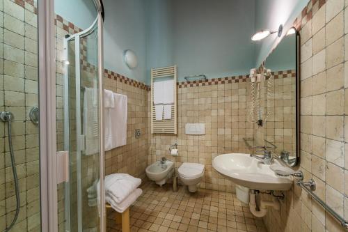ein Badezimmer mit Waschbecken, Toilette und Dusche in der Unterkunft Hotel Golf Inn in Lignano Sabbiadoro
