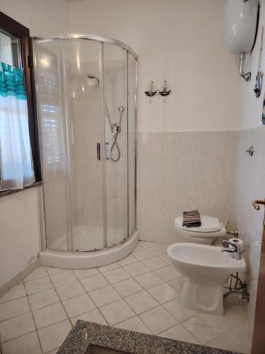 a white bathroom with a shower and a toilet at Bed & Breakfast Gli Alisei in Siniscola