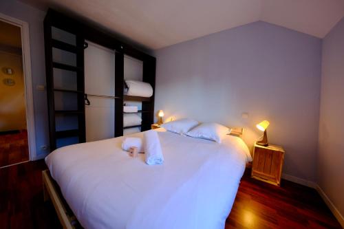 a bedroom with a large white bed with towels on it at Le toit des Carmes in Rouen