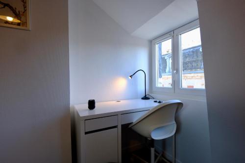 a white desk with a lamp and a chair in a room at Le toit des Carmes in Rouen