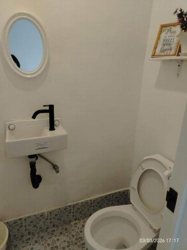 a bathroom with a white toilet and a sink at Pamarayeg Room in Bilar