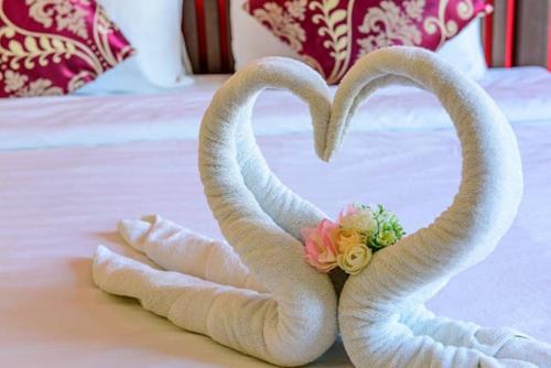 two towelsrendered to look like swans on a bed at Bebeladan ARA'S Lodging House Beachfront in El Nido